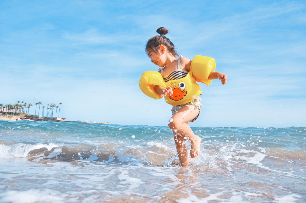 Girl at the beach playing in the waves