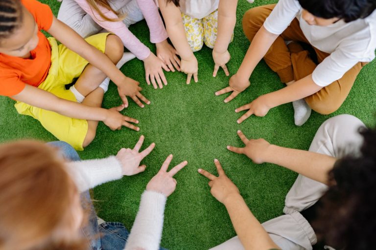 group of children playing on green grass - clubs for kids in Houston