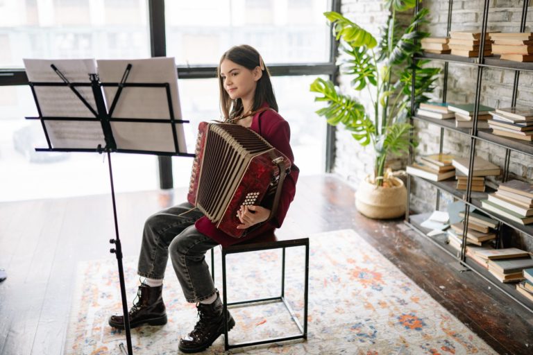 Music Lessons - girl looking at a music sheet while playing an accordion