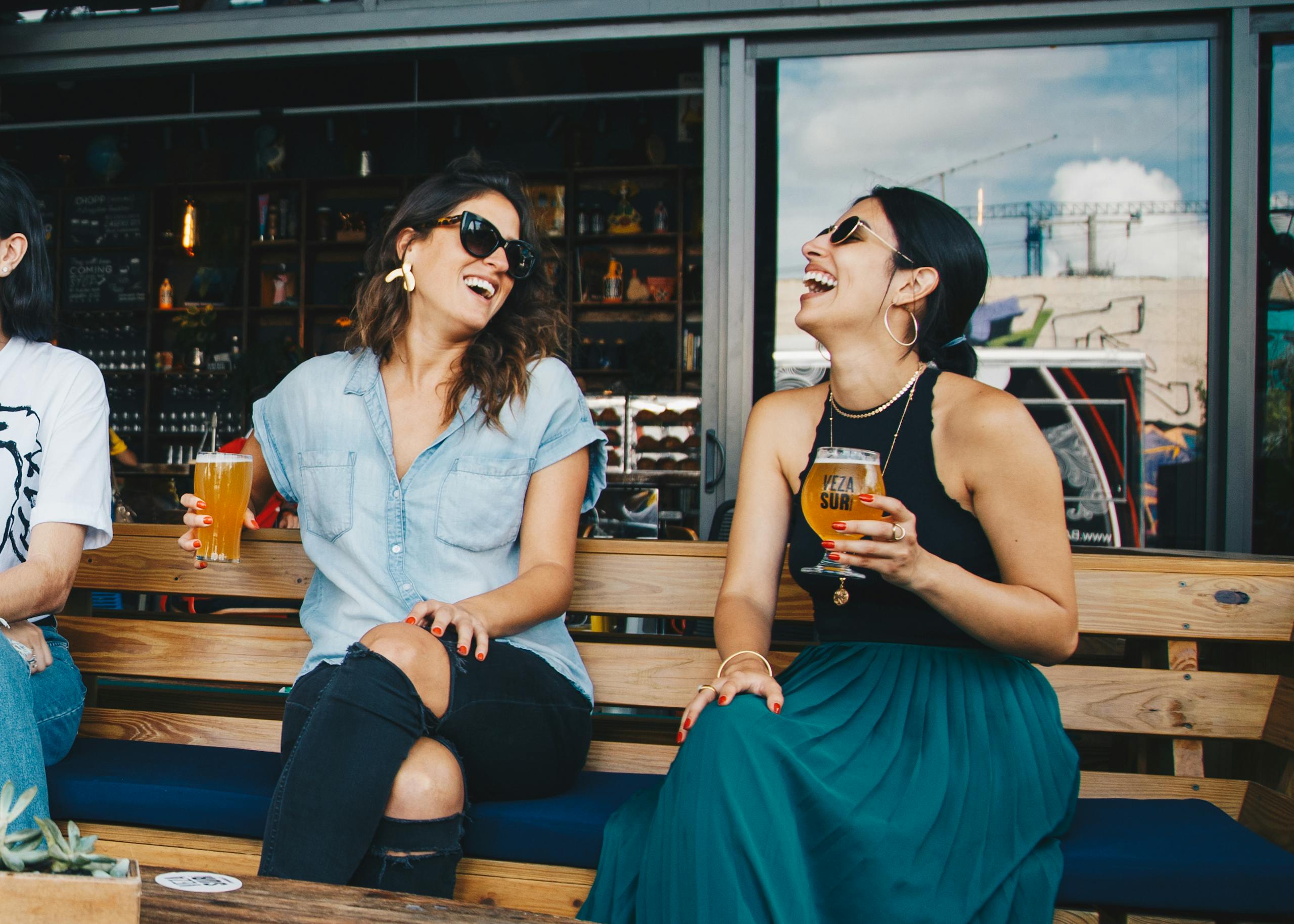 Two Smiling Women Sitting on Wooden Bench